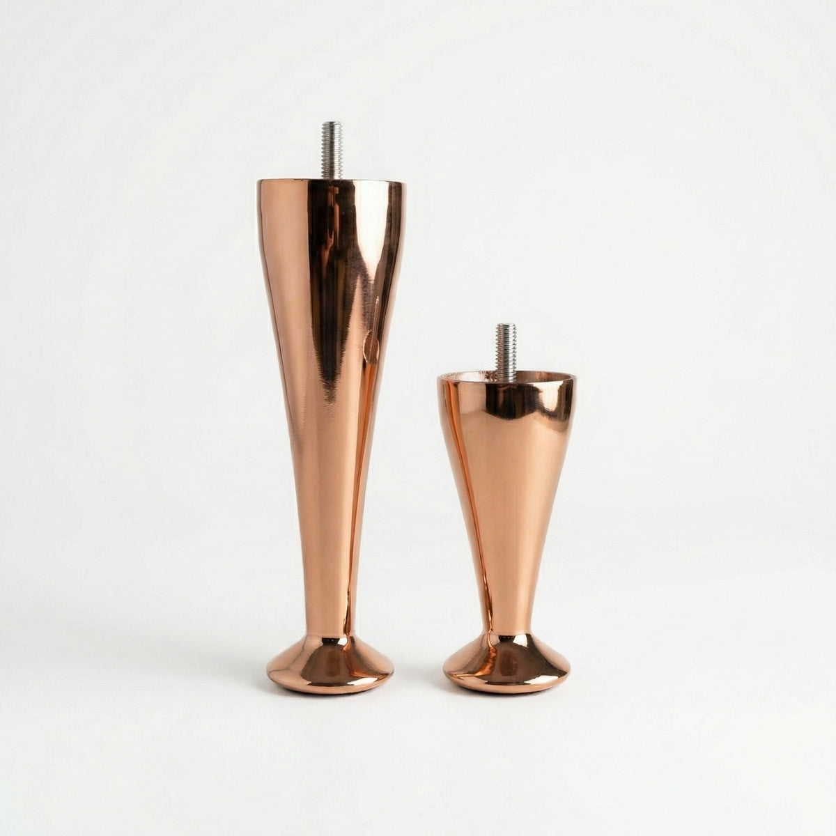 Two copper-coloured bed legs of different heights with waisted profiles