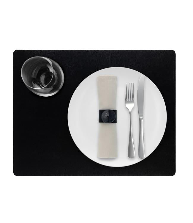 Black rectangular Finesse placemat with a white plate, cutlery and glass viewed from above