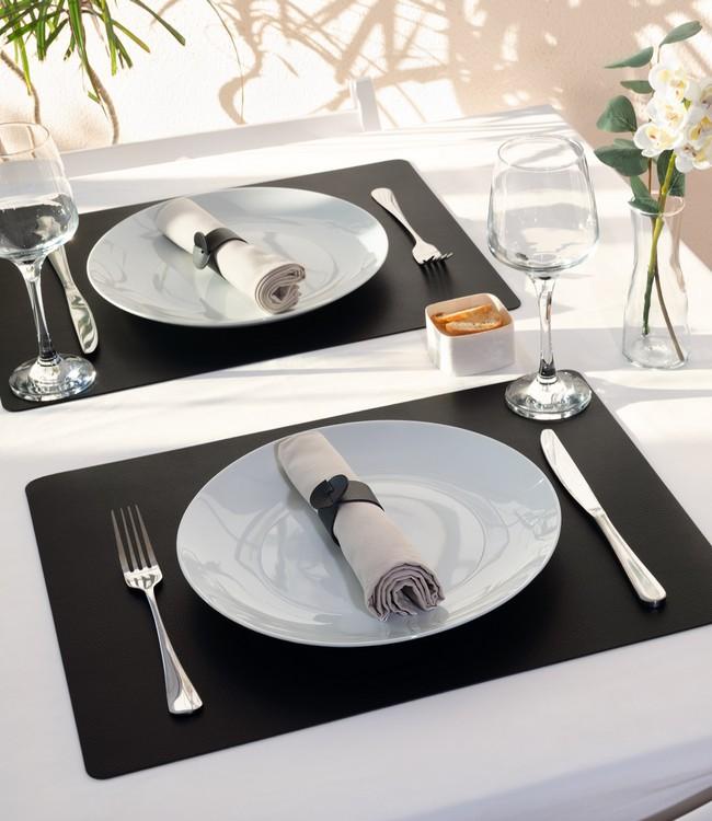 Finesse placemats in black beneath white plates and cloth napkins on a set table