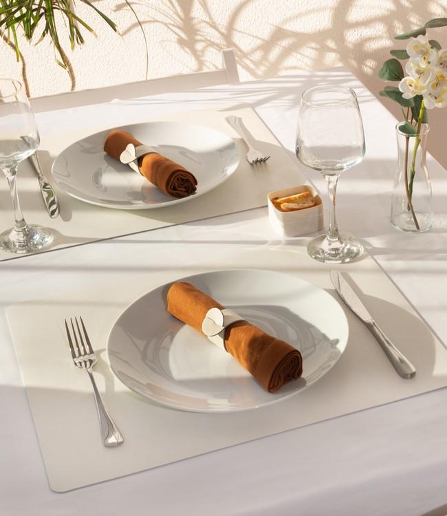 Finesse placemats in white beneath white plates and cloth napkins on a set table