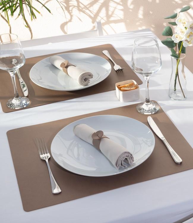 Finesse placemats in taupe beneath white plates and cloth napkins on a set table