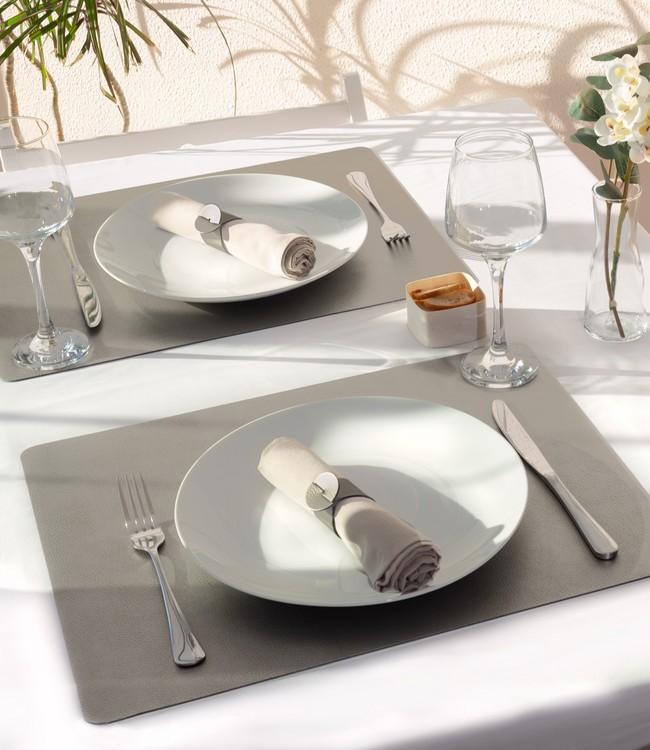 Finesse placemats in grey beneath white plates and cloth napkins on a set table
