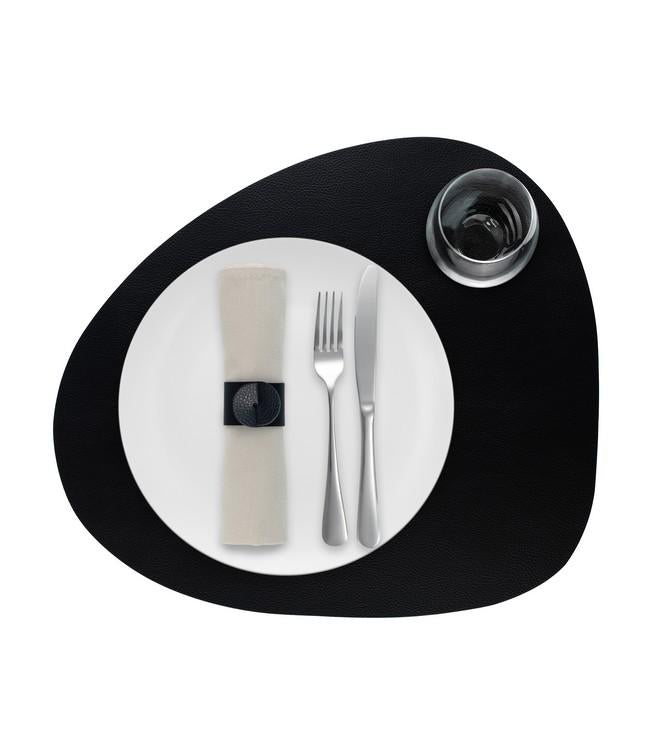 Svart rundad Finesse-bordstablett med vit tallrik, bestick och glas ovanifrån