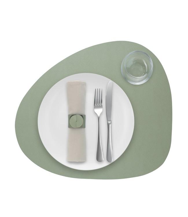 Grön rundad Finesse-bordstablett med vit tallrik, bestick och glas ovanifrån