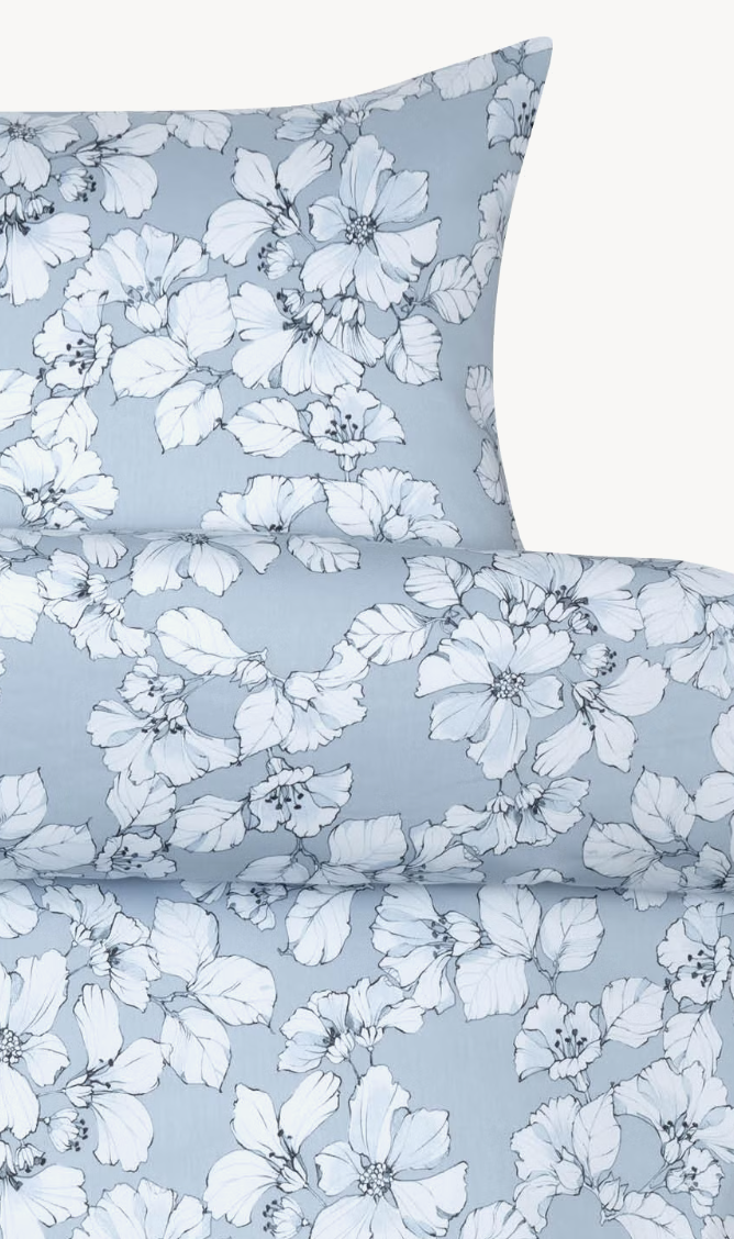 Høie Amelia pillowcase and duvet cover top edge with a white leaf pattern on a light blue background