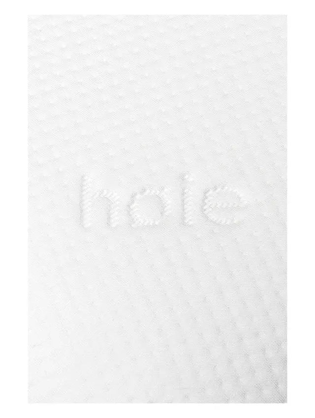 Close-up of the white knitted cover and Høie logo on a Classic Memoryfoam pillow