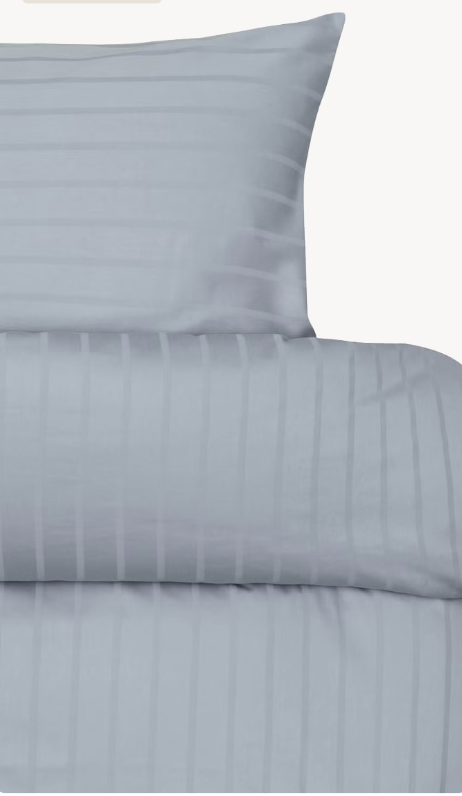 Light blue Høie Milano duvet cover set showing the pillowcase and turned-down top edge; subtle tonal stripes
