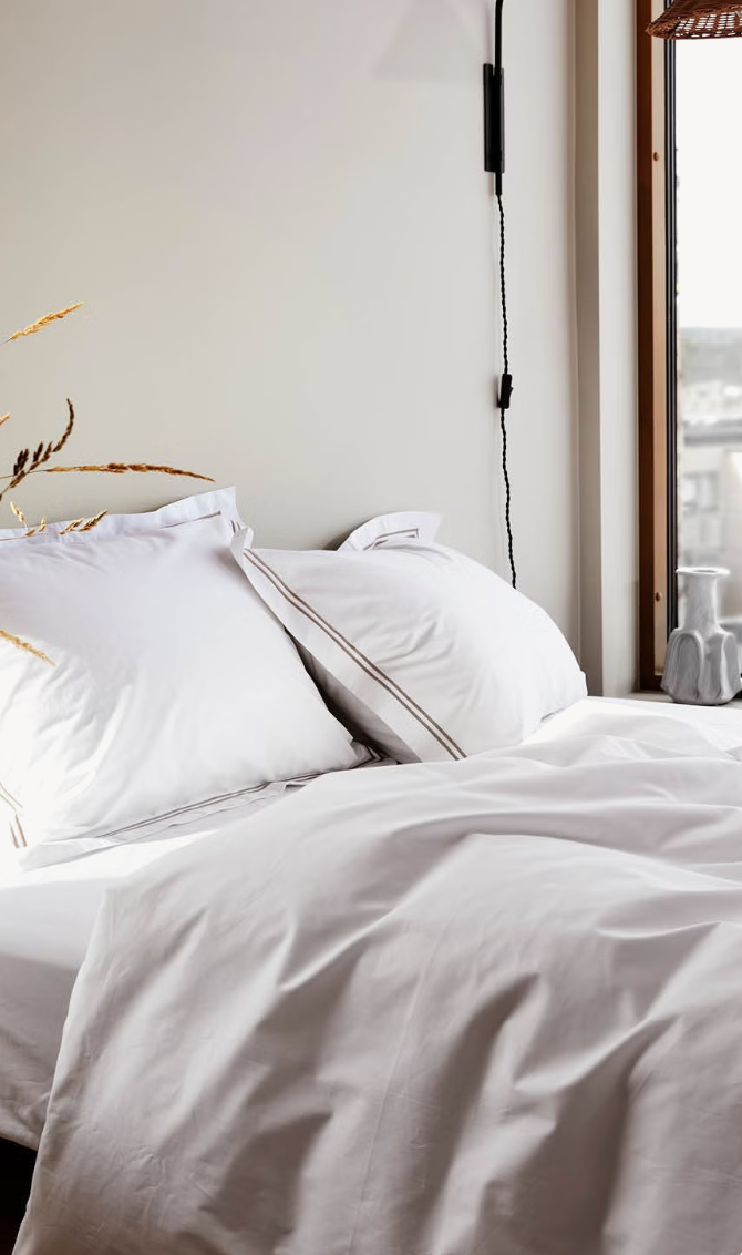 Close view of white Høie Paris pillows and duvet cover on a bed