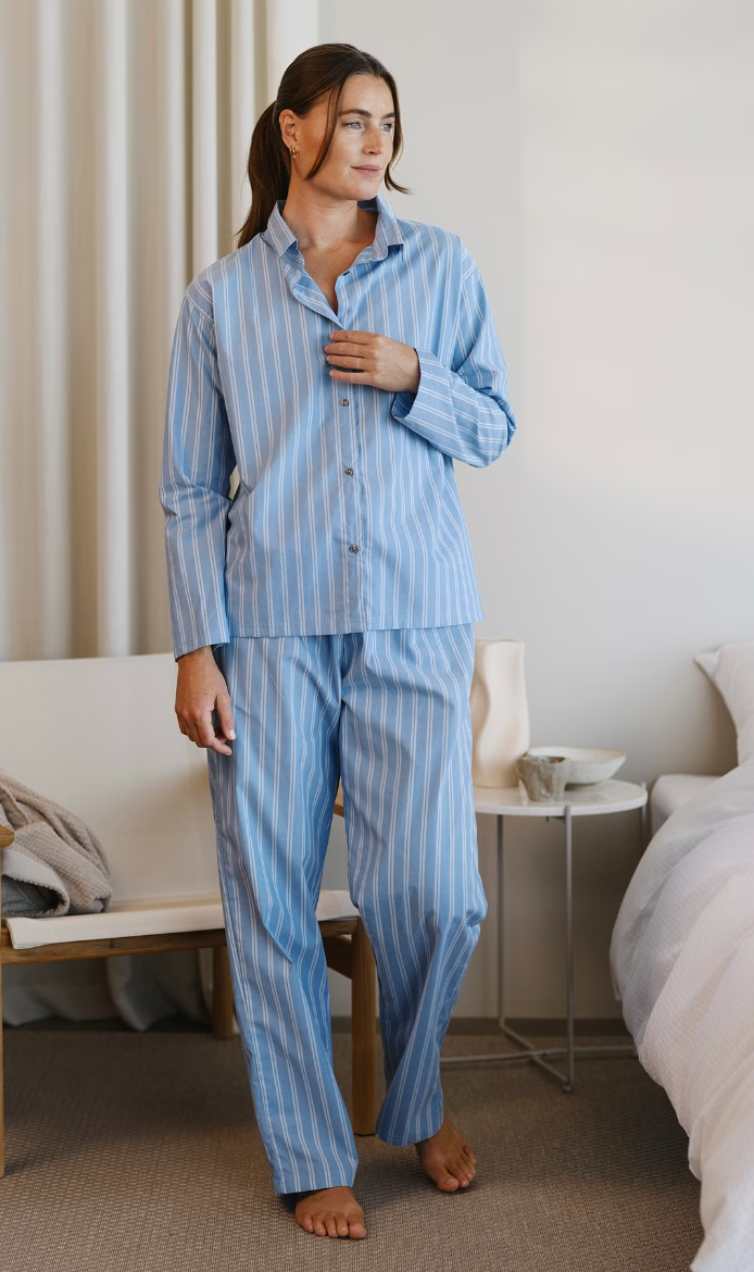 Person wearing a blue and white striped Høie Sana pyjama set with a long-sleeved shirt and long trousers