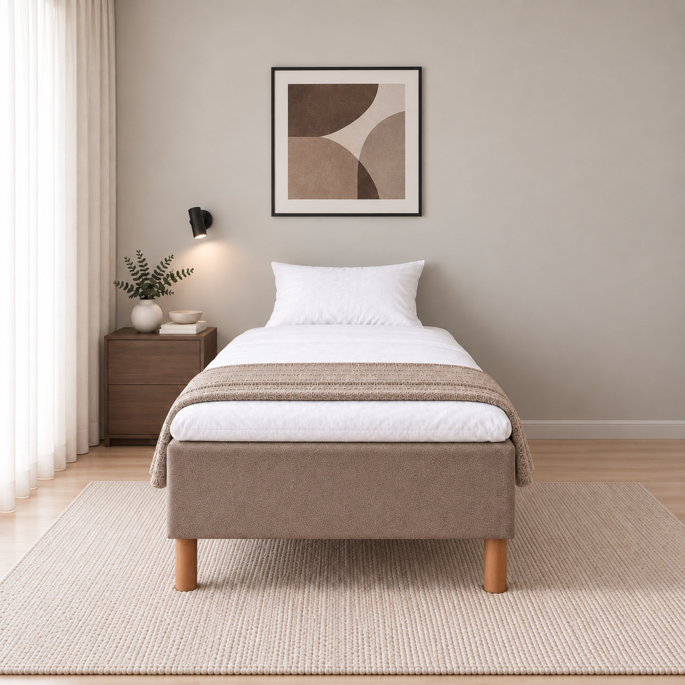 Hotel Basic Pocket runkosänky 100x200 cm, Sawana 25 ruskea modernissa makuuhuoneessa suoraan jalkopäästä kuvattuna. Sisustushavainnekuva; Hotel Plus -petauspatja sisältyy hintaan, vuodevaatteet eivät.