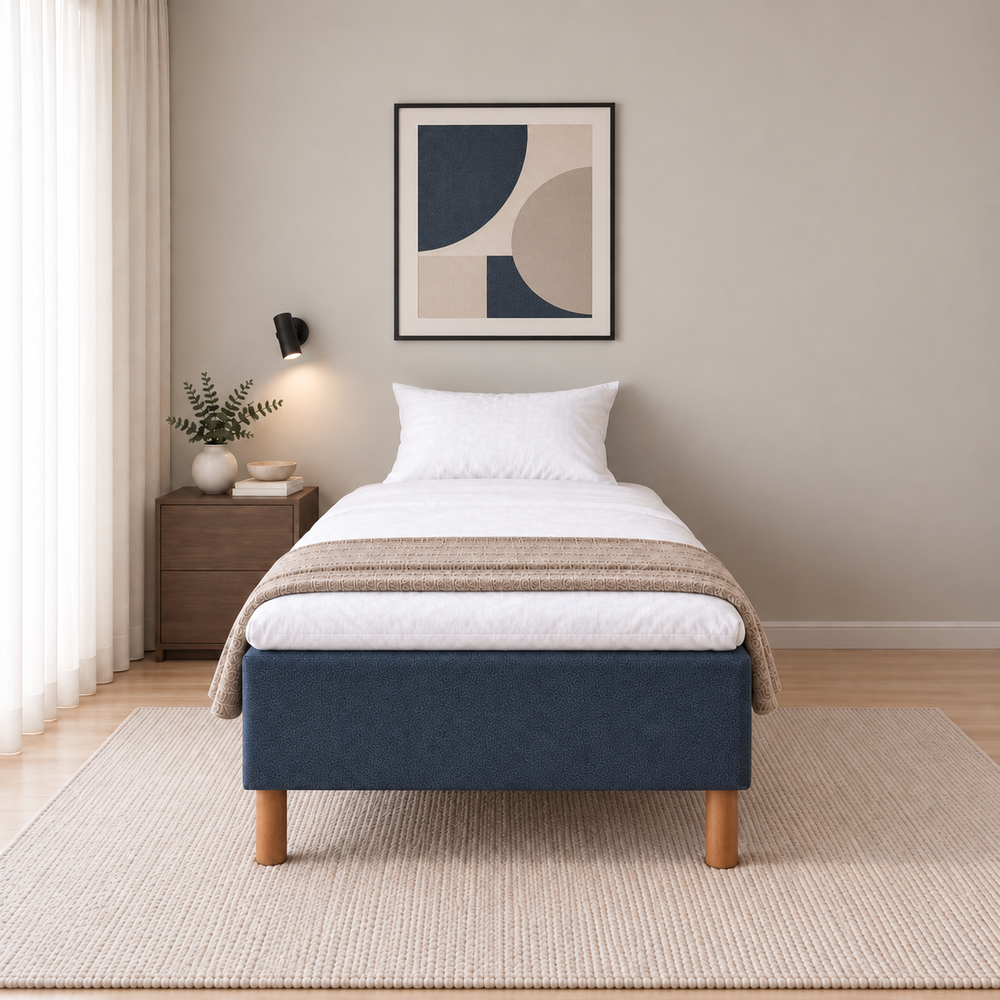 Hotel Basic Pocket runkosänky 100x200 cm, Sawana 80 sininen modernissa makuuhuoneessa suoraan jalkopäästä kuvattuna. Sisustushavainnekuva; Hotel Plus -petauspatja sisältyy hintaan, vuodevaatteet eivät.
