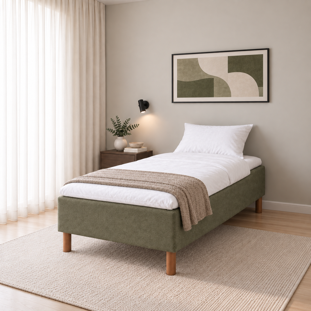Hotel Basic Pocket runkosänky 100x200 cm, Thomas 20 vihreä modernissa makuuhuoneessa viistosti jalkopäästä kuvattuna. Sisustushavainnekuva; Hotel Plus -petauspatja sisältyy hintaan, vuodevaatteet eivät.