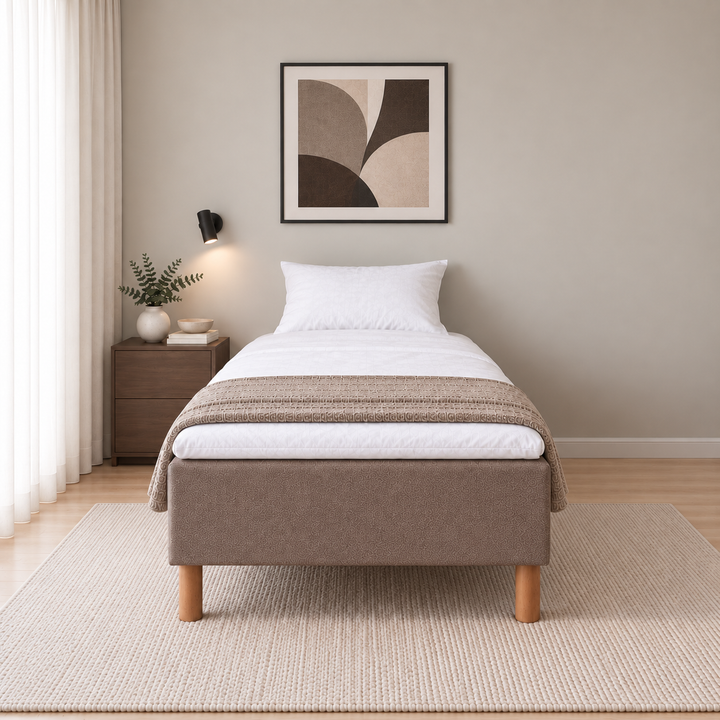 Hotel Basic Pocket runkosänky 120x200 cm, Sawana 25 ruskea modernissa makuuhuoneessa suoraan jalkopäästä kuvattuna. Sisustushavainnekuva; Hotel Plus -petauspatja sisältyy hintaan, vuodevaatteet eivät.