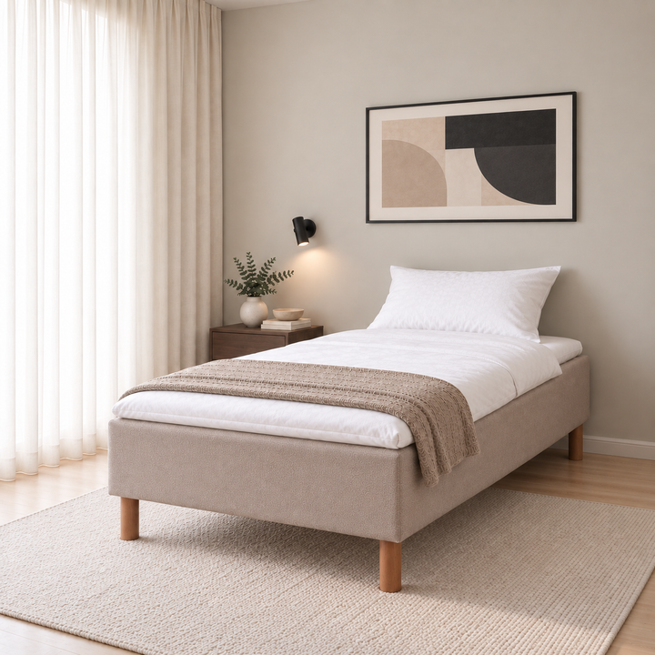 Hotel Basic Pocket runkopatja, No Problem 120x200 cm, Thomas 03 beige modernissa makuuhuoneessa viistosti jalkopäästä kuvattuna. Sisustushavainnekuva; petauspatja ja vuodevaatteet eivät sisälly runkopatjaan.