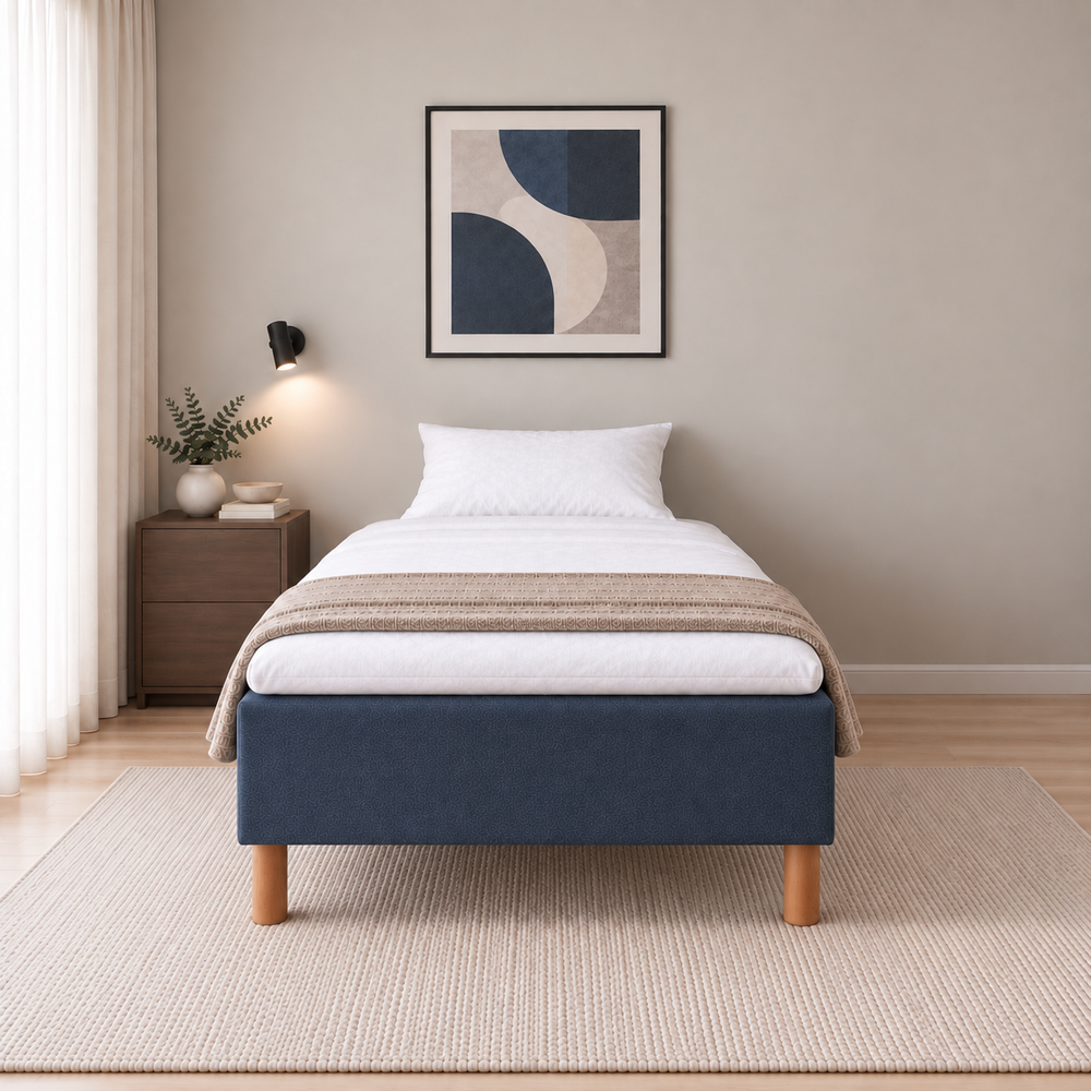 Hotel Basic Pocket runkosänky 140x200 cm, Sawana 80 sininen modernissa makuuhuoneessa, suoraan jalkopäästä kuvattuna. Yksi tyyny. Sisustushavainnekuva; Hotel Plus -petauspatja sisältyy hintaan, vuodevaatteet eivät.
