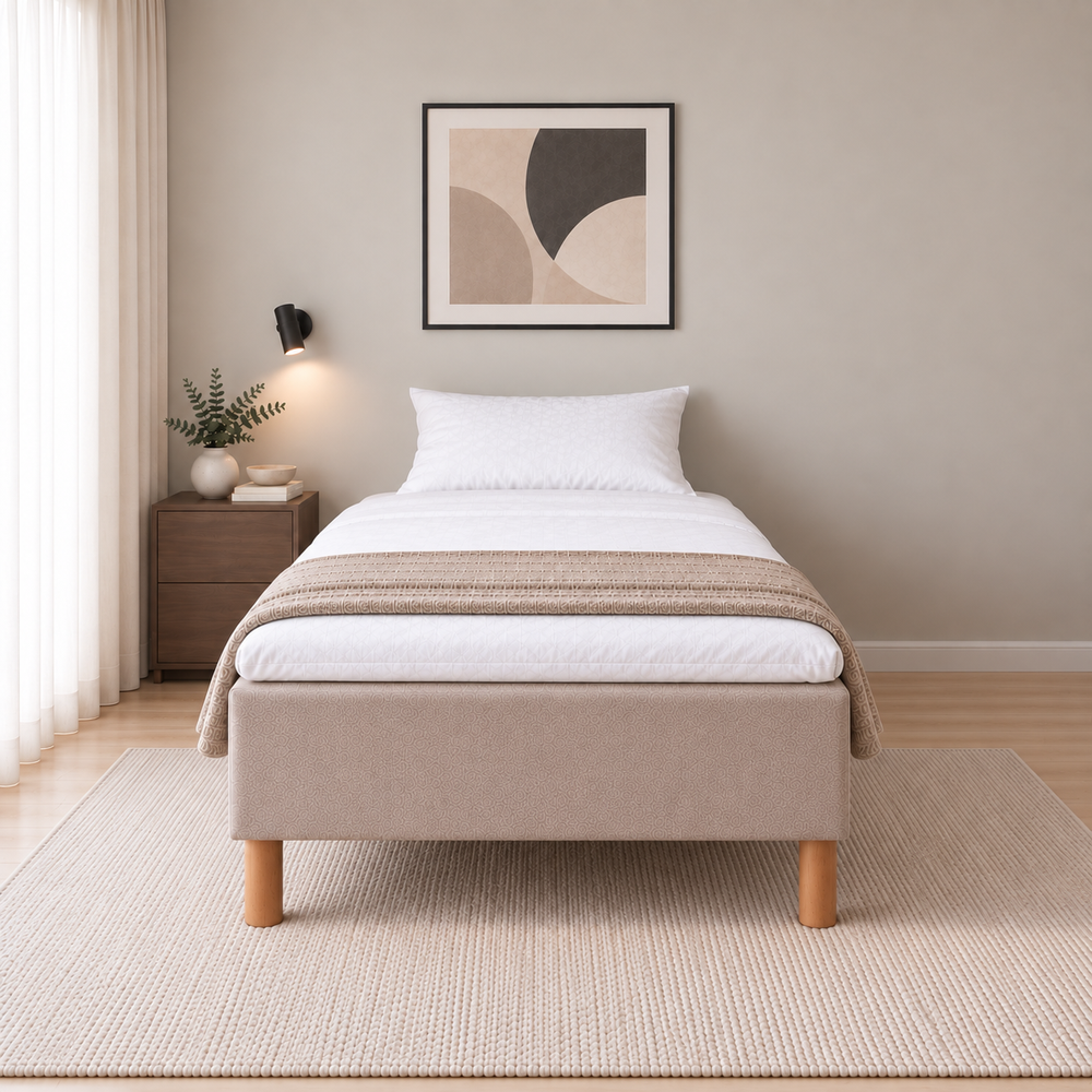 Hotel Basic Pocket runkosänky 140x200 cm, Thomas 03 beige modernissa makuuhuoneessa, suoraan jalkopäästä kuvattuna. Yksi tyyny. Sisustushavainnekuva; Hotel Plus -petauspatja sisältyy hintaan, vuodevaatteet eivät.