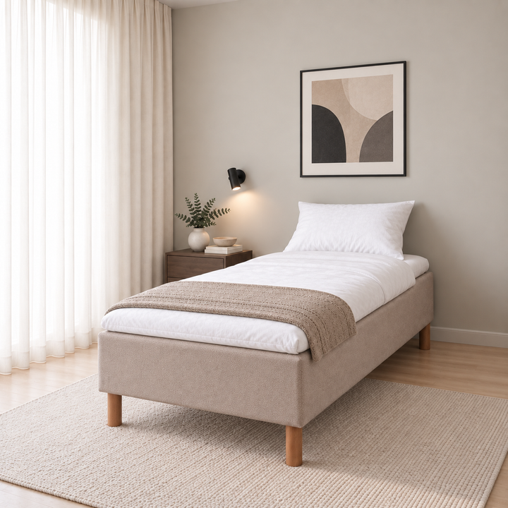 Hotel Basic Pocket runkosänky 80x200 cm, Thomas 03 beige modernissa makuuhuoneessa viistosti jalkopäästä kuvattuna. Sisustushavainnekuva; Hotel Plus -petauspatja sisältyy hintaan, vuodevaatteet eivät.