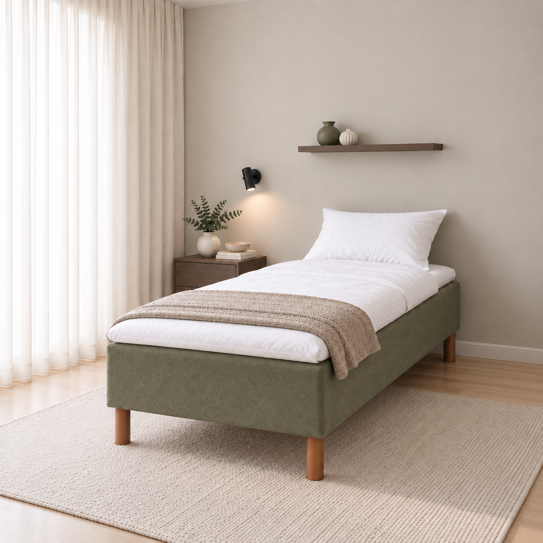 Hotel Basic Pocket runkosänky 80x200 cm, Thomas 20 vihreä modernissa makuuhuoneessa viistosti jalkopäästä kuvattuna. Sisustushavainnekuva; Hotel Plus -petauspatja sisältyy hintaan, vuodevaatteet eivät.