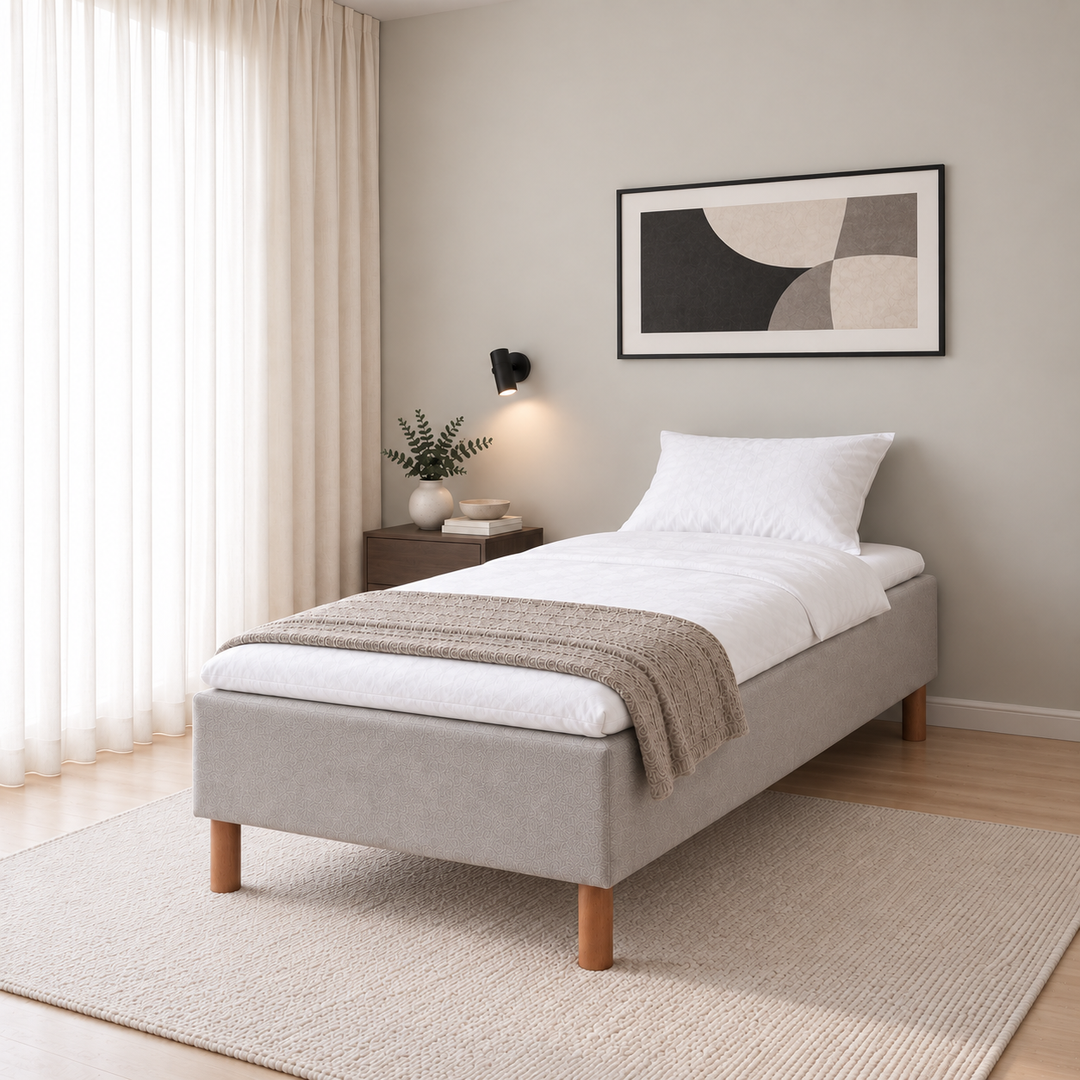 Hotel Basic Pocket runkopatja, No Problem 80x200 cm, Vogue 14 vaaleanharmaa modernissa makuuhuoneessa viistosti jalkopäästä kuvattuna. Sisustushavainnekuva; petauspatja ja vuodevaatteet eivät sisälly runkopatjaan.