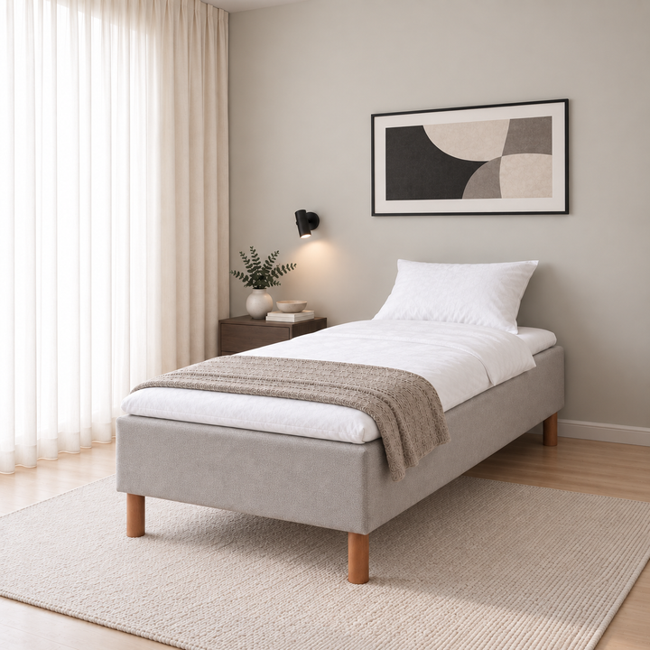 Hotel Basic Pocket runkopatja, No Problem 80x200 cm, Vogue 14 vaaleanharmaa modernissa makuuhuoneessa viistosti jalkopäästä kuvattuna. Sisustushavainnekuva; petauspatja ja vuodevaatteet eivät sisälly runkopatjaan.