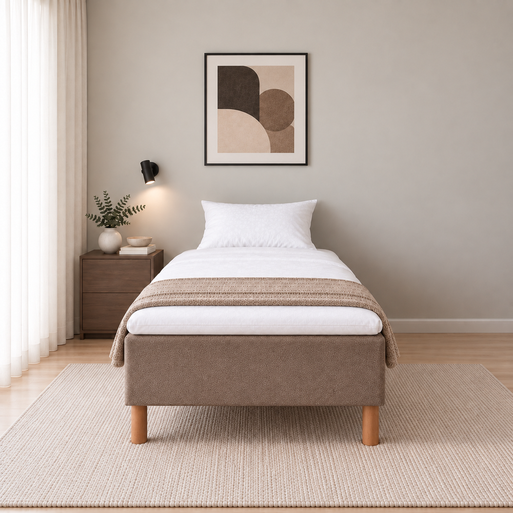 Hotel Basic Pocket runkosänky 90x200 cm, Sawana 25 ruskea modernissa makuuhuoneessa suoraan jalkopäästä kuvattuna. Sisustushavainnekuva; Hotel Plus -petauspatja sisältyy hintaan, vuodevaatteet eivät.