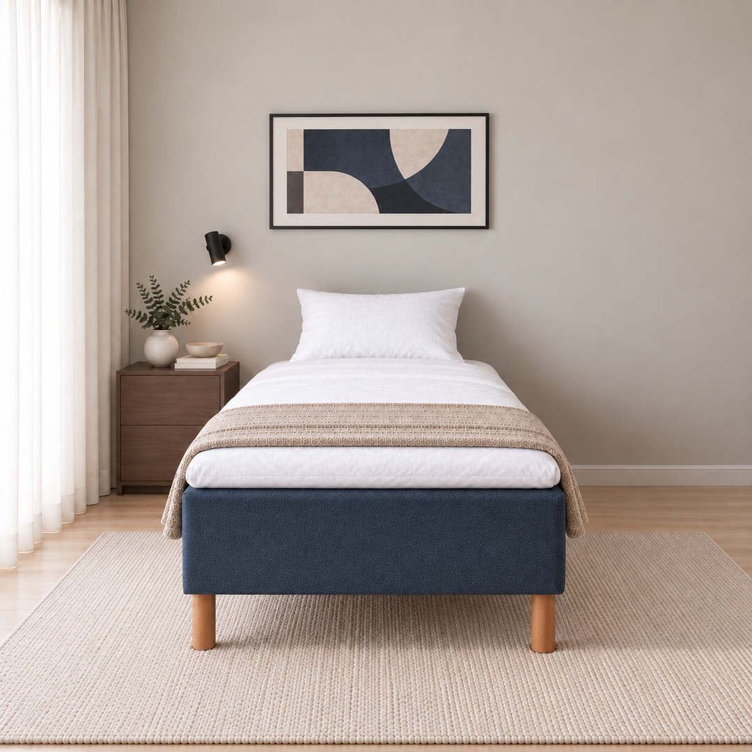Hotel Basic Pocket runkosänky 90x200 cm, Sawana 80 sininen modernissa makuuhuoneessa suoraan jalkopäästä kuvattuna. Sisustushavainnekuva; Hotel Plus -petauspatja sisältyy hintaan, vuodevaatteet eivät.