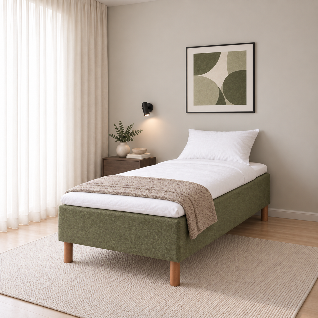 Hotel Basic Pocket runkosänky 90x200 cm, Thomas 20 vihreä modernissa makuuhuoneessa viistosti jalkopäästä kuvattuna. Sisustushavainnekuva; Hotel Plus -petauspatja sisältyy hintaan, vuodevaatteet eivät.