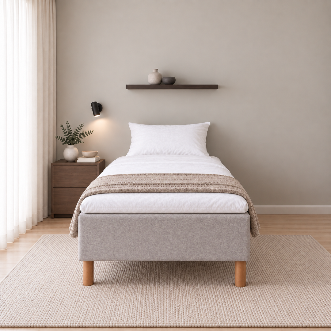 Hotel Basic Pocket runkopatja, No Problem 90x200 cm, Vogue 14 vaaleanharmaa modernissa makuuhuoneessa suoraan jalkopäästä kuvattuna. Sisustushavainnekuva; petauspatja ja vuodevaatteet eivät sisälly runkopatjaan.