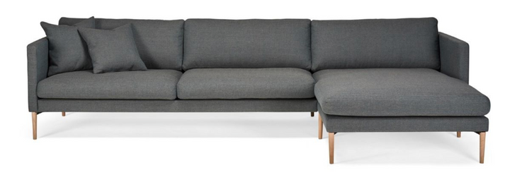 Dark grey Hotel Luxus Elegant chaise sofa with wooden legs and the chaise on the right in the image