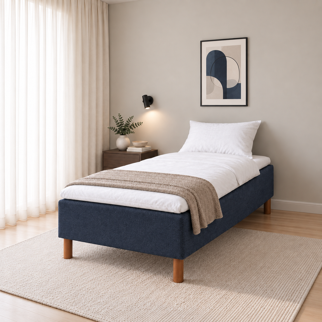 Hotel Luxus Pocket Bonnel runkosänky 100x200 cm, Sawana 80 sininen modernissa makuuhuoneessa viistosti jalkopäästä kuvattuna. Sisustushavainnekuva; Hotel Plus -petauspatja sisältyy hintaan, vuodevaatteet eivät.