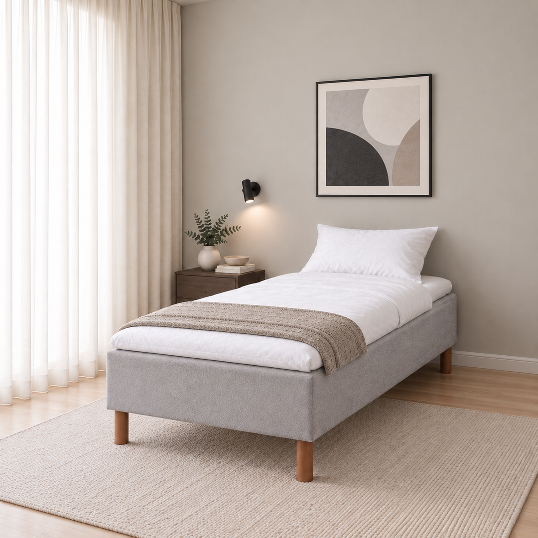 Hotel Luxus Pocket Bonnel runkosänky 100x200 cm, Vogue 14 vaaleanharmaa modernissa makuuhuoneessa viistosti jalkopäästä kuvattuna. Sisustushavainnekuva; Hotel Plus -petauspatja sisältyy hintaan, vuodevaatteet eivät.