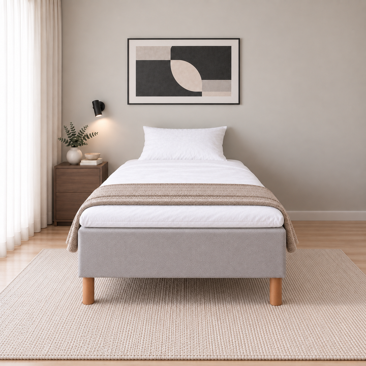 Hotel Luxus Pocket Bonnel runkosänky 140x200 cm, Vogue 14 vaaleanharmaa modernissa makuuhuoneessa, suoraan jalkopäästä kuvattuna. Yksi tyyny. Sisustushavainnekuva; Hotel Plus -petauspatja sisältyy hintaan, vuodevaatteet eivät.