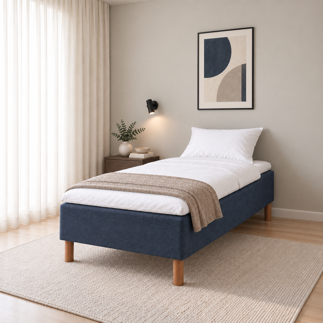 Hotel Luxus Pocket Bonnel runkosänky 80x200 cm, Sawana 80 sininen modernissa makuuhuoneessa viistosti jalkopäästä kuvattuna. Sisustushavainnekuva; Hotel Plus -petauspatja sisältyy hintaan, vuodevaatteet eivät.