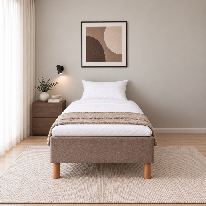 Hotel Luxus Pocket Bonnel runkosänky 90x200 cm, Sawana 25 ruskea modernissa makuuhuoneessa suoraan jalkopäästä kuvattuna. Sisustushavainnekuva; Hotel Plus -petauspatja sisältyy hintaan, vuodevaatteet eivät.