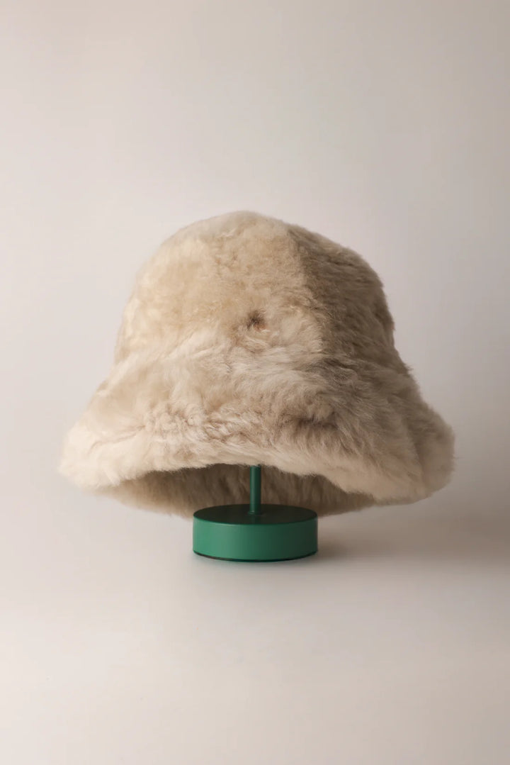Ljus KYWIE Fluffy-hatt på grönt ställ med mjukt nedvikt brätte