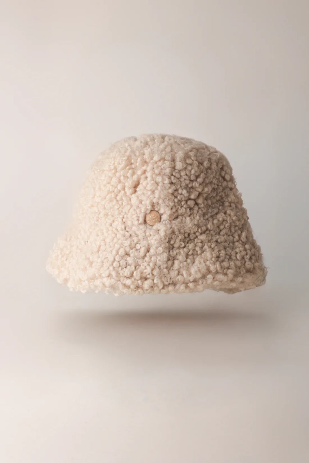 Cream curly-textured KYWIE Natural sheepswool hat with the brim down
