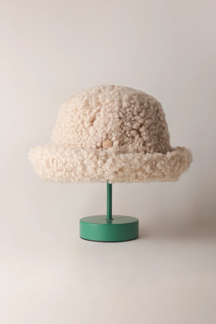 Cream KYWIE Natural hat on a green stand with the brim turned up