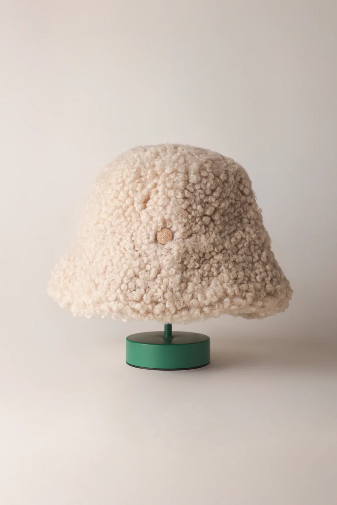 Cream KYWIE Natural hat on a green stand with the brim down