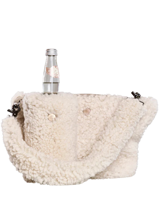 White KYWIE sheepswool bag with a chain strap and a bottle inside