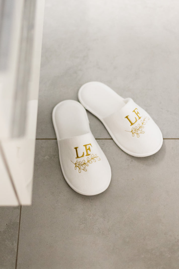 Valkoiset Loffen Hotel Luxus -kylpytossut harmaalla laattalattialla suihkun vieressä