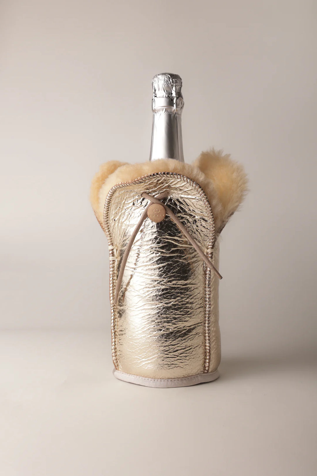 Hopeanvärinen metallinhohtoinen Kywie-pullocooler pullon ympärillä, kiristysnyöri ja pehmeä yläreuna näkyvissä